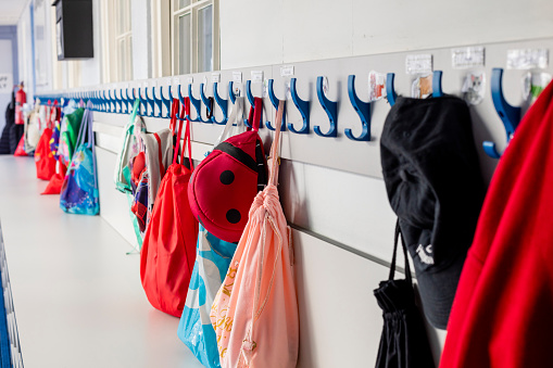 Coats and bags hung up on pegs in a primary school in the North East of England.