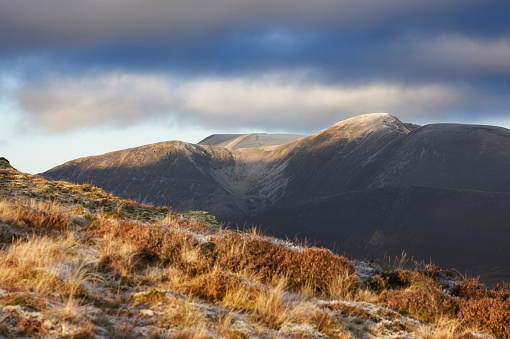 A winters morning sunrise catching the mountain tops of Eel Crag, Crag Hill with Grasmoor in the distance. Lake District UK.