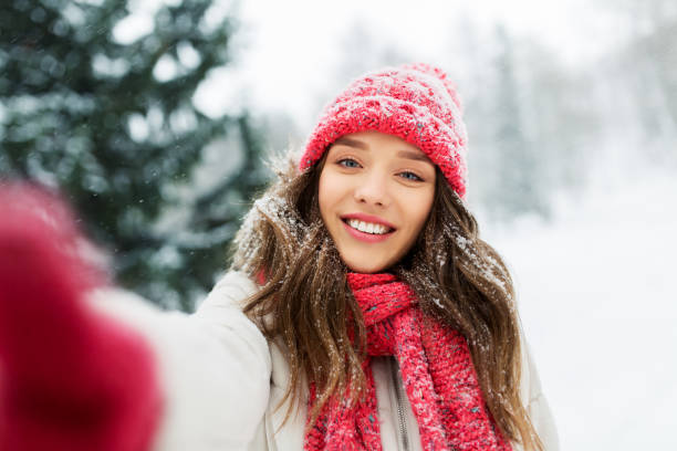 istock smiling woman taking selfie outdoors in winter 1346510427