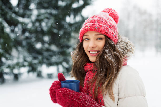 istock happy young woman with tea cup in winter park 1346510820