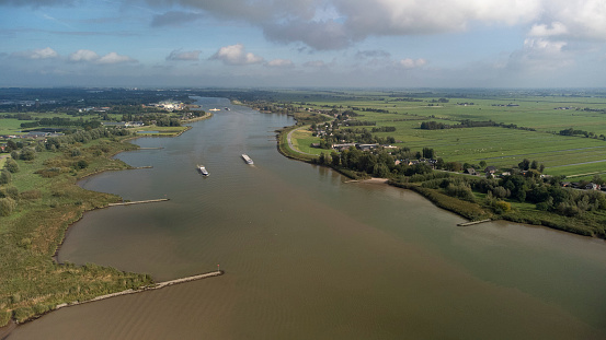 Inland container barge on River Lek aerial view near the village of Bergambacht, South Holland, Netherlands
