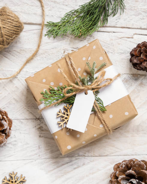 istock Christmas present with blank gift tag top view, Mockup 1346519051