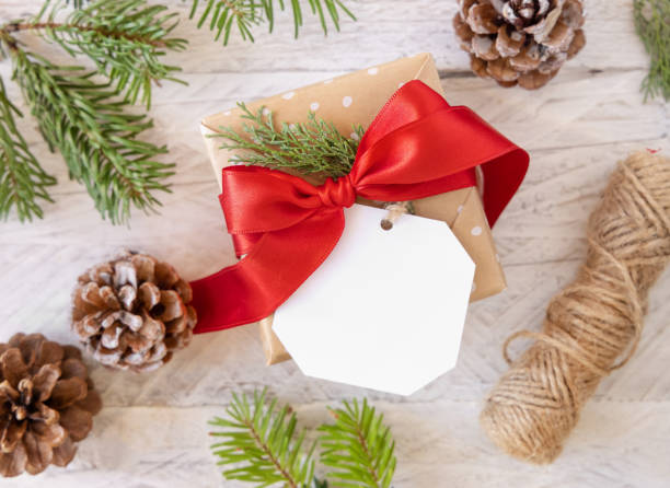 istock Christmas present with blank gift tag top view, Mockup 1346519075