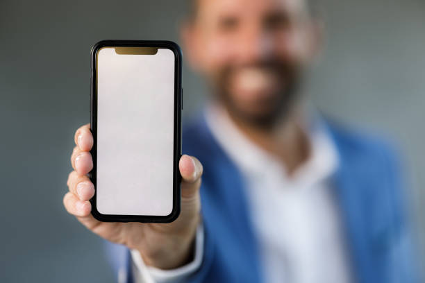 istock Close up of cell phone with blank screen in man's hand. 1346519829