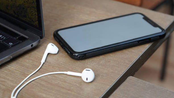 istock Mokcup Smartphone with earphone on table with Laptop 1346520406