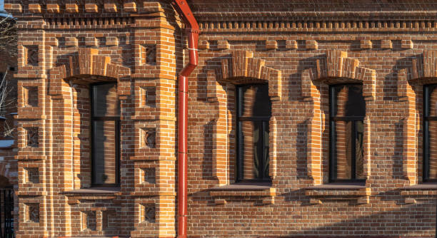istock Three windows of the old mansion 19 century with brown bricks wall 1346524356