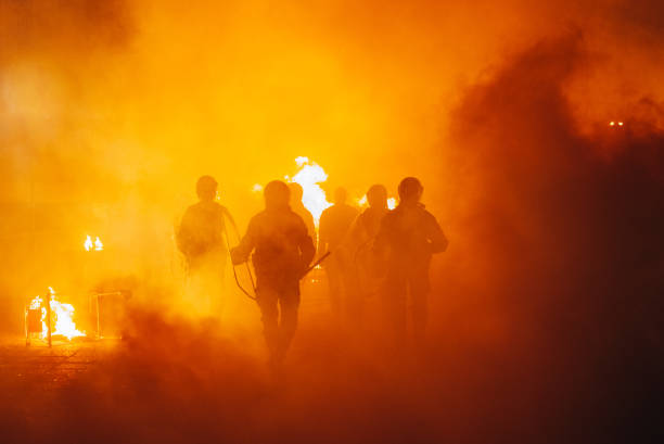 Riot In The City Silhouette of armored police officers  running  in front of the fire riot photos stock pictures, royalty-free photos & images