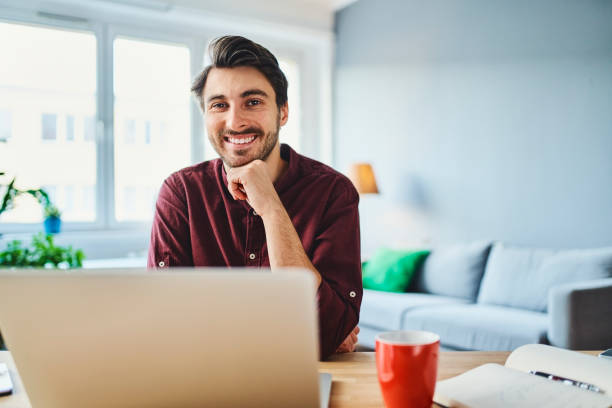 istock Smiling young man working as freelancer from home office 1346528344