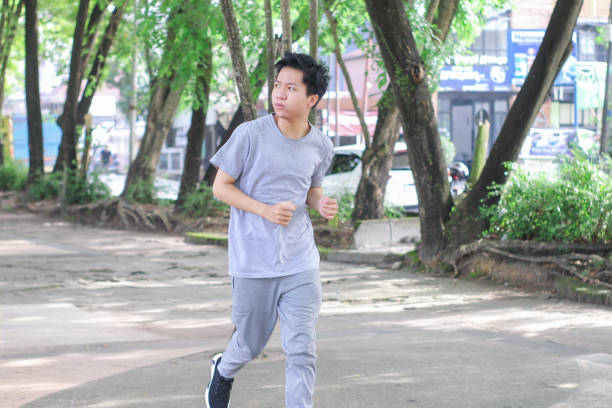 istock Young men doing jogging at a public park during a sunny day 1346528734