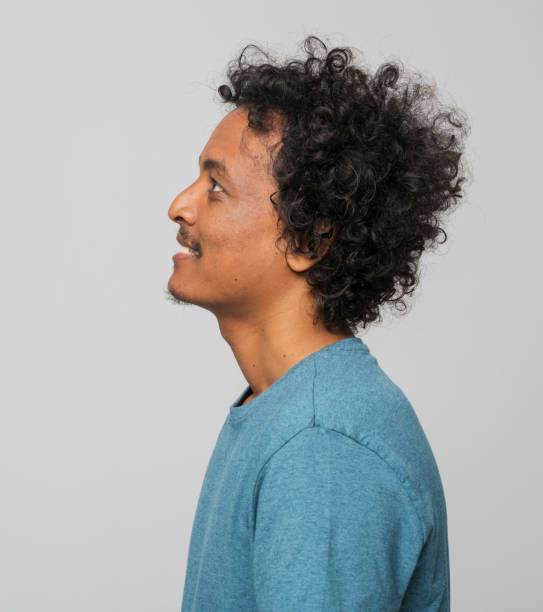 istock Profile of smiling young man looking up 1346530108