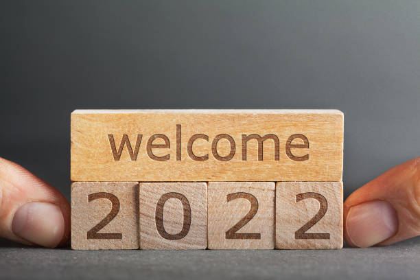 istock welcome 2022  inscription engraved on blocks that hold fingers on a gray background 1346530398