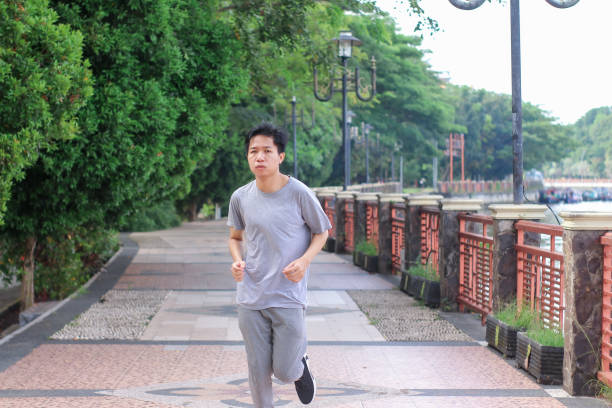 istock Young men doing jogging at a public park during a sunny day 1346530569