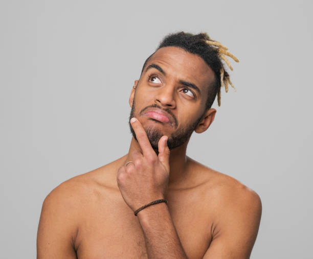 istock Close-up of thoughtful young man looking up 1346530675
