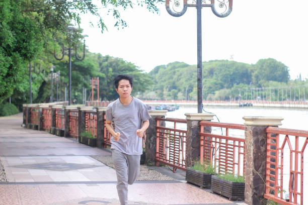 istock Young men doing jogging at a public park during a sunny day 1346530789
