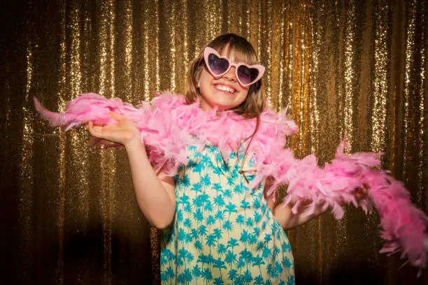 Portrait of happy girl wearing feather boa and comedy glasses while enjoying the party.