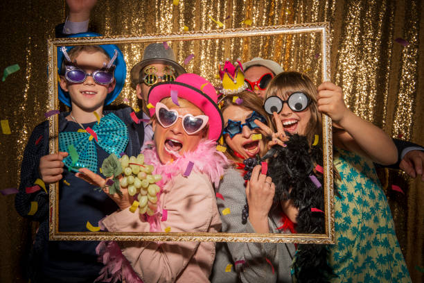 amigos masculinos y femeninos tomando fotos divertidas durante la fiesta - cabina de fotos fotografías e imágenes de stock