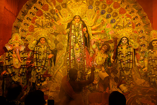 Kolkata, West Bengal, India - 7th October 2019 : Goddess Durga is being worshipped by Hindu priest with holy panchapradip during sondhipujo aarti with holy smoke.