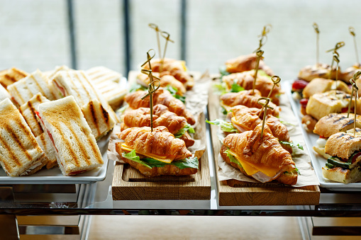 Stacks of croissant sandwich at event.