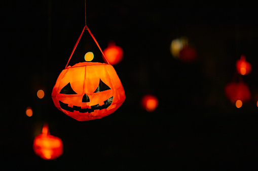 Glowing Halloween Lanterns Hanging Outdoors.