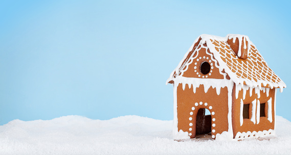 Christmas greeting card with gingerbread house in snow and copy space