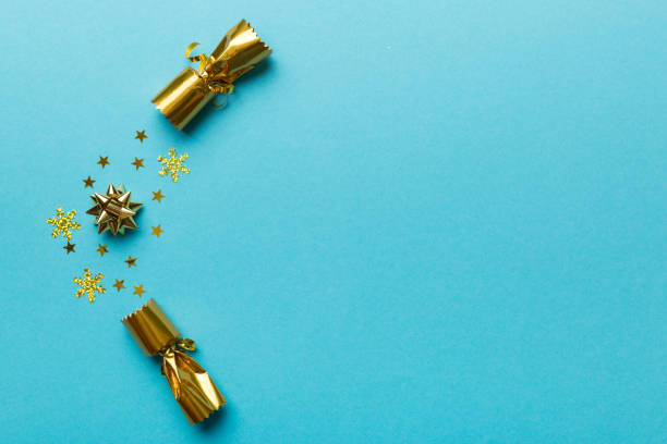 istock Christmas crackers with shiny confetti on color background, top view, copy space 1346537629