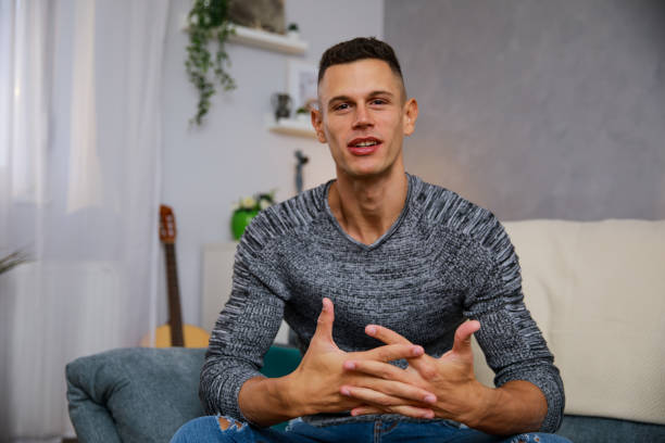 Young man having a job interview over a video conference Front view of a confident young man smiling at camera as if he is on a
video call. He is gesturing while talking during a job interview. man video call pov stock pictures, royalty-free photos & images