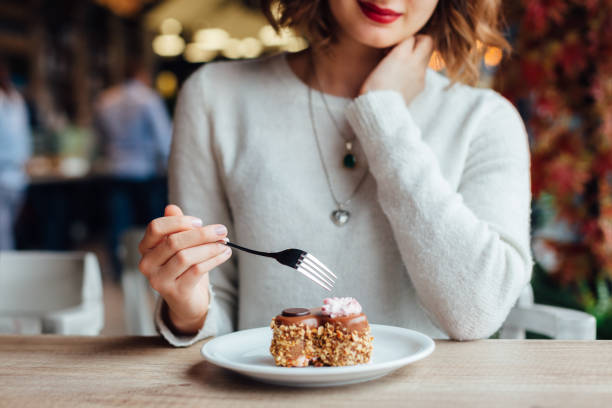 istock Woman Eating Cake In A Cafe 1346538849