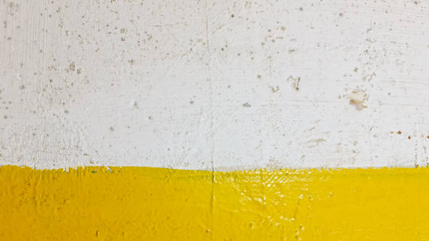 istock The Yellow paint on old surface. Yellow and white paint on the wall. 1346538880