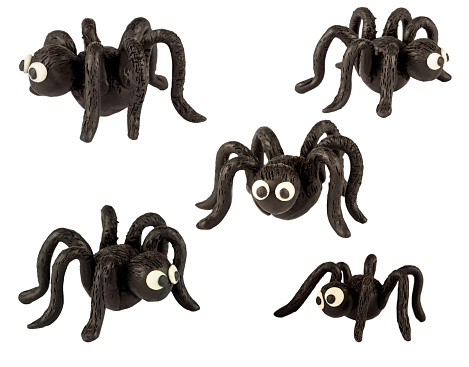 Set of funny black spiders made of plasticine. Isolated on a white background.