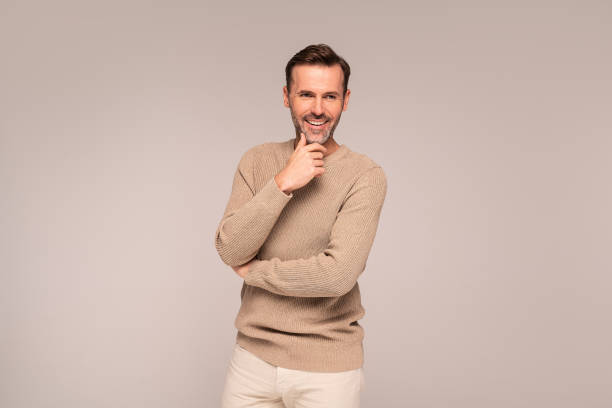istock Cheerful handsome guy in fashionable autumn sweater posing in studio 1346540301