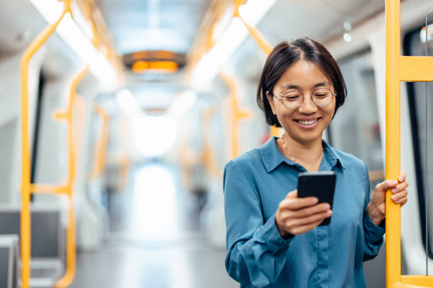 istock Smiling woman using smart phone in public transport. 1346542079