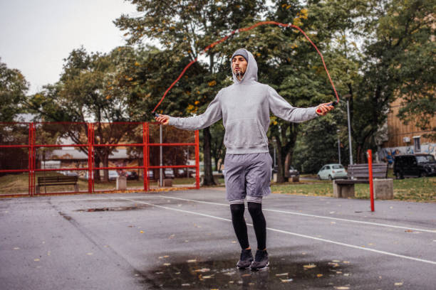 istock Young man with jumping rope on an autumn day training 1346542136