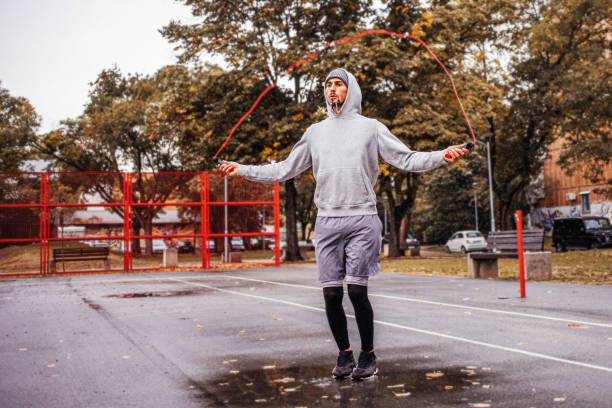 Young man with jumping rope on an autumn day training and prepares for the competition