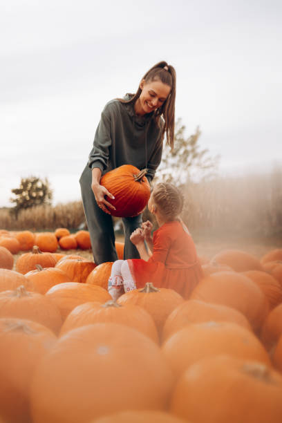 istock Mother and her disabled daughter spend time on a pumpkin field 1346542223