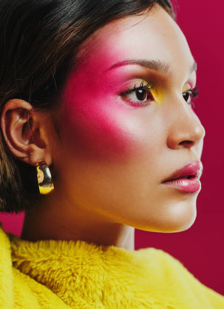 shot of a young woman posing against a pink background - fashion women stage makeup fashion model imagens e fotografias de stock