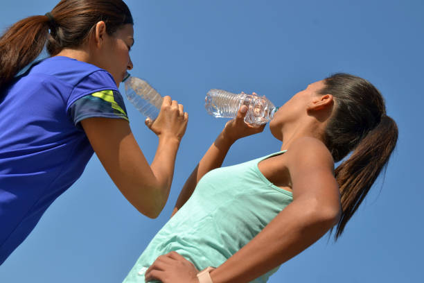 istock young latin women drinking water bottle after outdoors training 1346542695