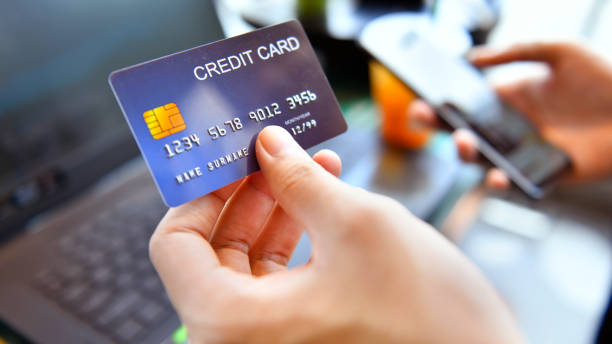 istock Hands holding a credit card and using smart phone for online shopping 1346543724