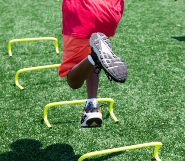 istock Legs of young athlete running over mini hurdles 1346544335