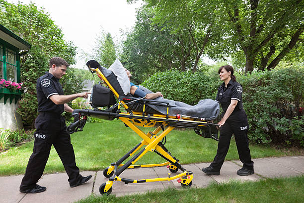 Senior on Ambulance Stretcher Senior woman on emergency medical stretcher being transported from home stretcher stock pictures, royalty-free photos & images
