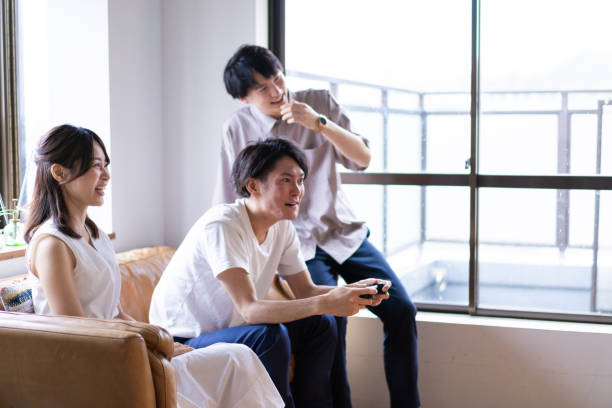 istock Young men and women playing video games at home 1346549685