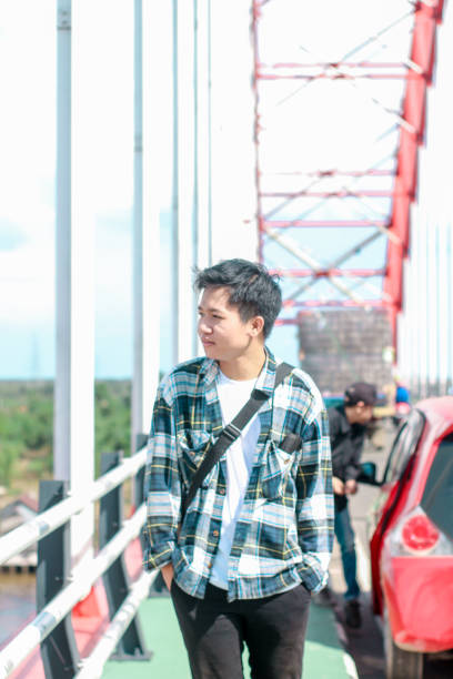 istock Young Men walking enjoying at the bridge on sunny day 1346550280