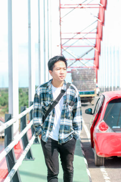 istock Young Men walking enjoying at the bridge on sunny day 1346550357