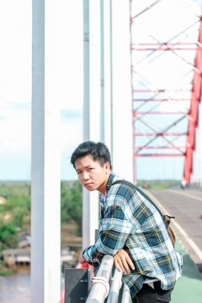 istock Young Men walking enjoying at the bridge in sunny day 1346550457