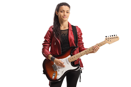 Young female rock star with an electric guitar posing isolated on white background