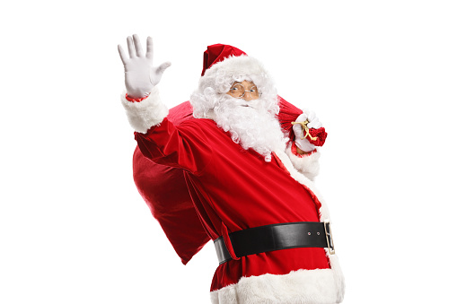 Santa claus waving and carrying a sack of presents isolated on white background