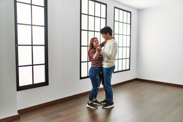 istock Young hispanic couple smiling happy dancing at empty new home. 1346553818