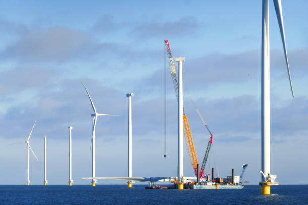 строительство оффшорной ветропарка - ветрогенератора в нидерландах на море (маркермер). крановое судно готовится к подъему ротора ветроген - mode of transport water sea sun стоковые фото и изображения