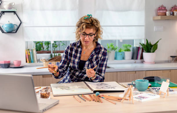 istock Attractive woman doing a drawing with a pencil in the notebook 1346554447