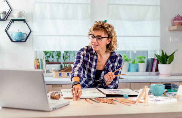 istock Attractive woman doing a drawing with a pencil in the notebook 1346554469