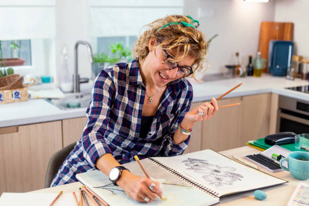 istock Attractive woman doing a drawing with a pencil in the notebook 1346554494